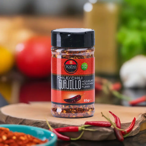 Guajillo Getrocknete Chiliflocken von Xatze, 85g, in einem Gewürzglas mit rotem Etikett. Aromatische und milde Würze für Saucen und Marinaden.